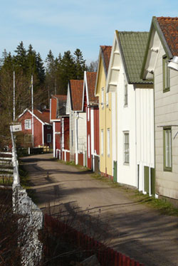 Gata med gamla trähus i olika färger i Ulvöhamn